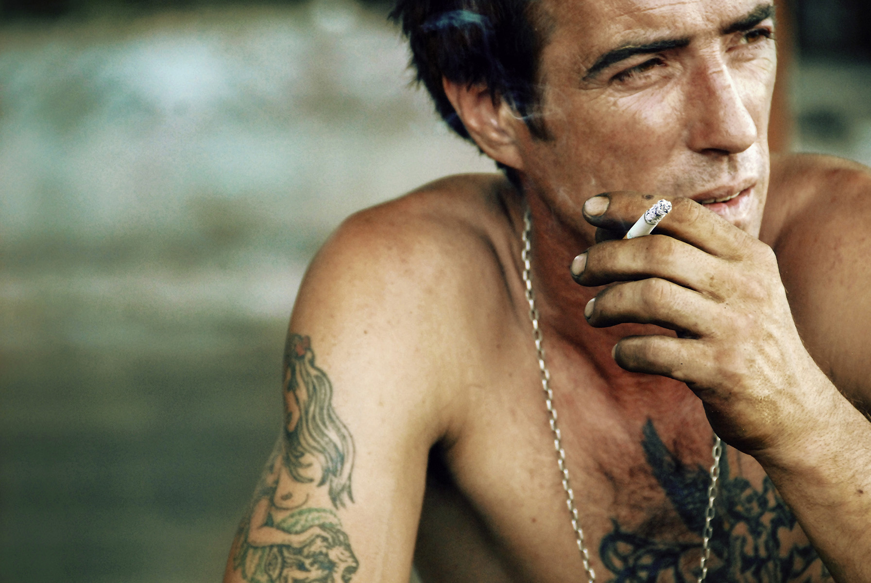 uomo seduto fuma una sigaretta