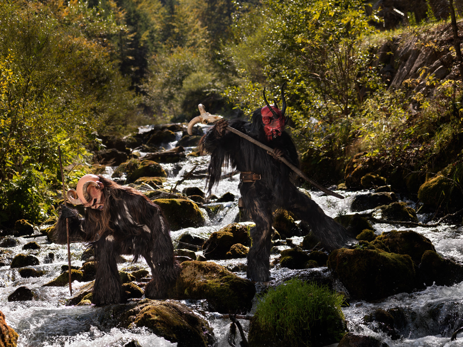 coppia di krampus pesca nel fiume con i bastoni