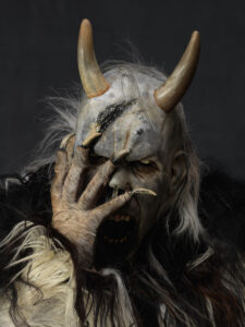 krampus nasconde il suo viso con la mano
