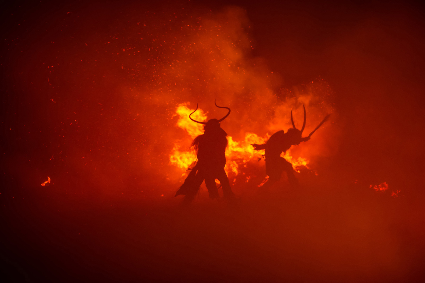 coppia di krampus balla tra il fuoco di notte