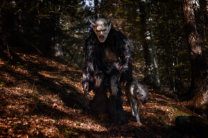 krampus cammina nel bosco assieme ad un lupo
