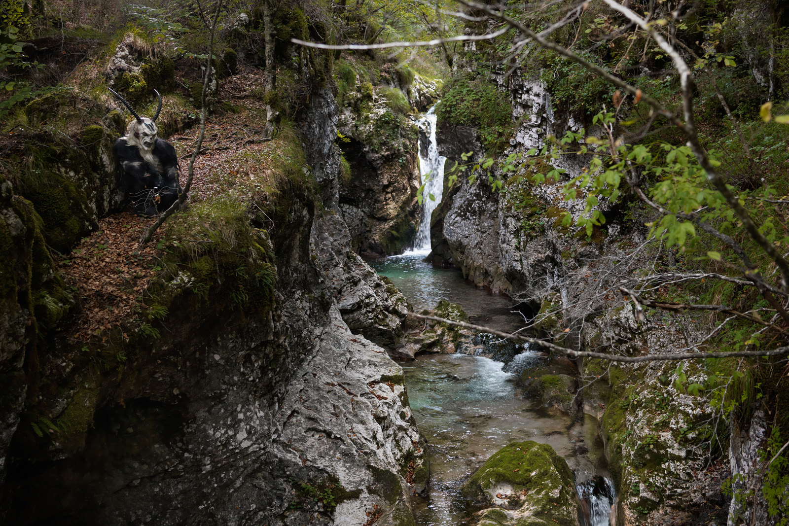 krampus inginocchiato sulla riva del torrente