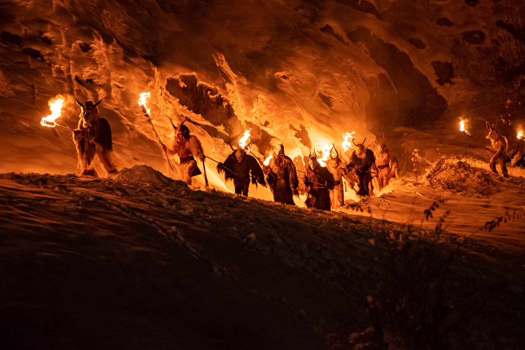 krampus camminano di notte in fila con le fiaccole infuocate