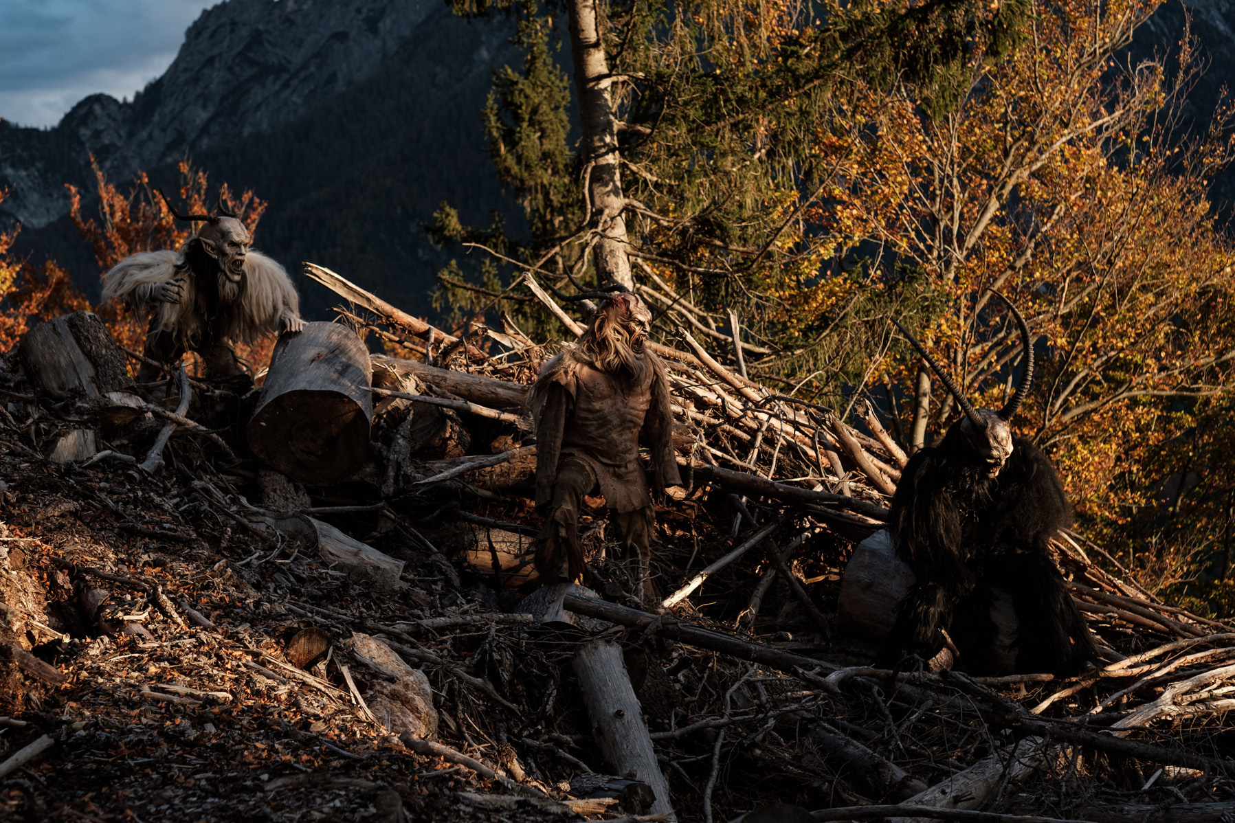 Krampus si nascondonoi tra i tronchi al tramonto in montagna