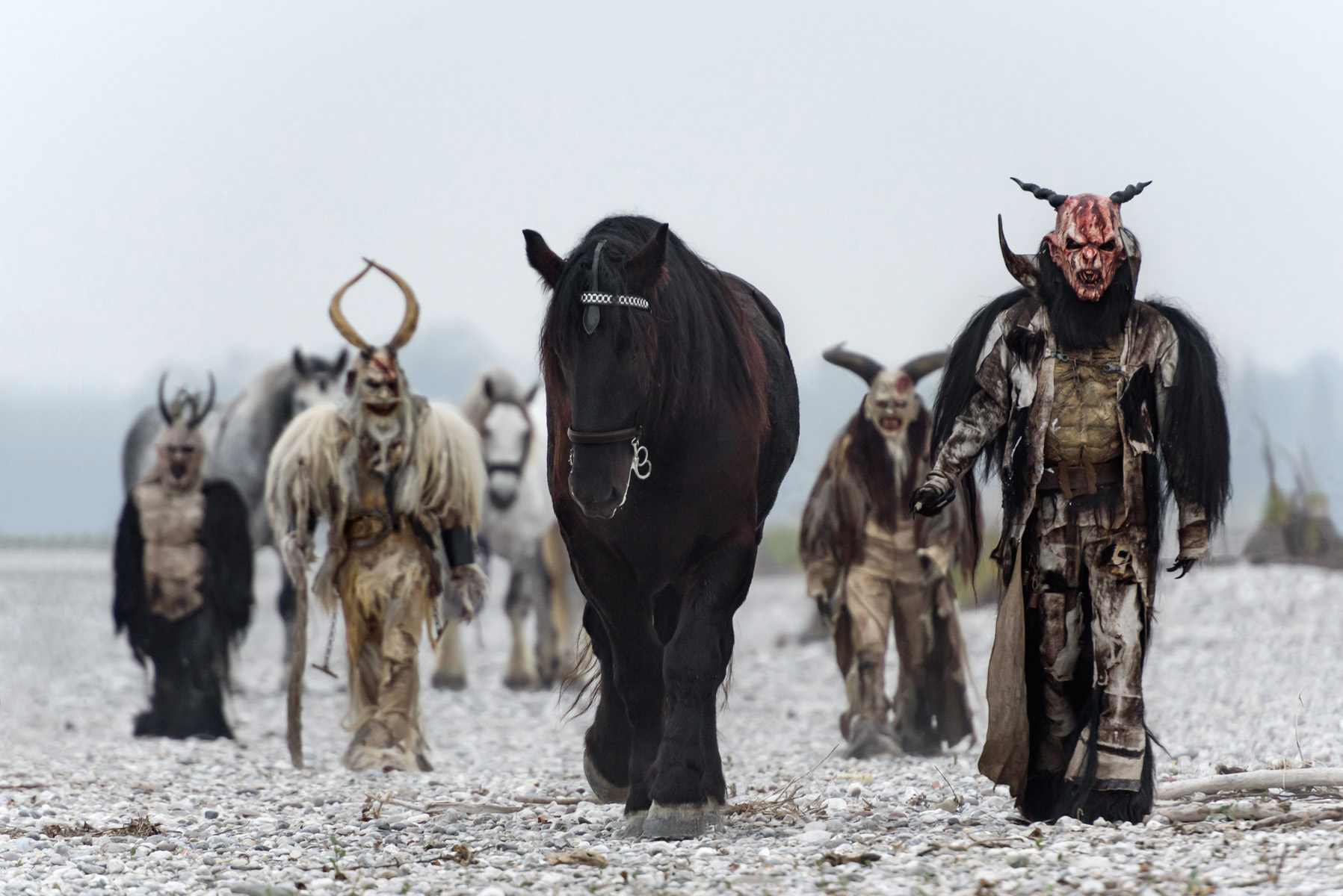 gruppo di Krampus cammina con i cavalli